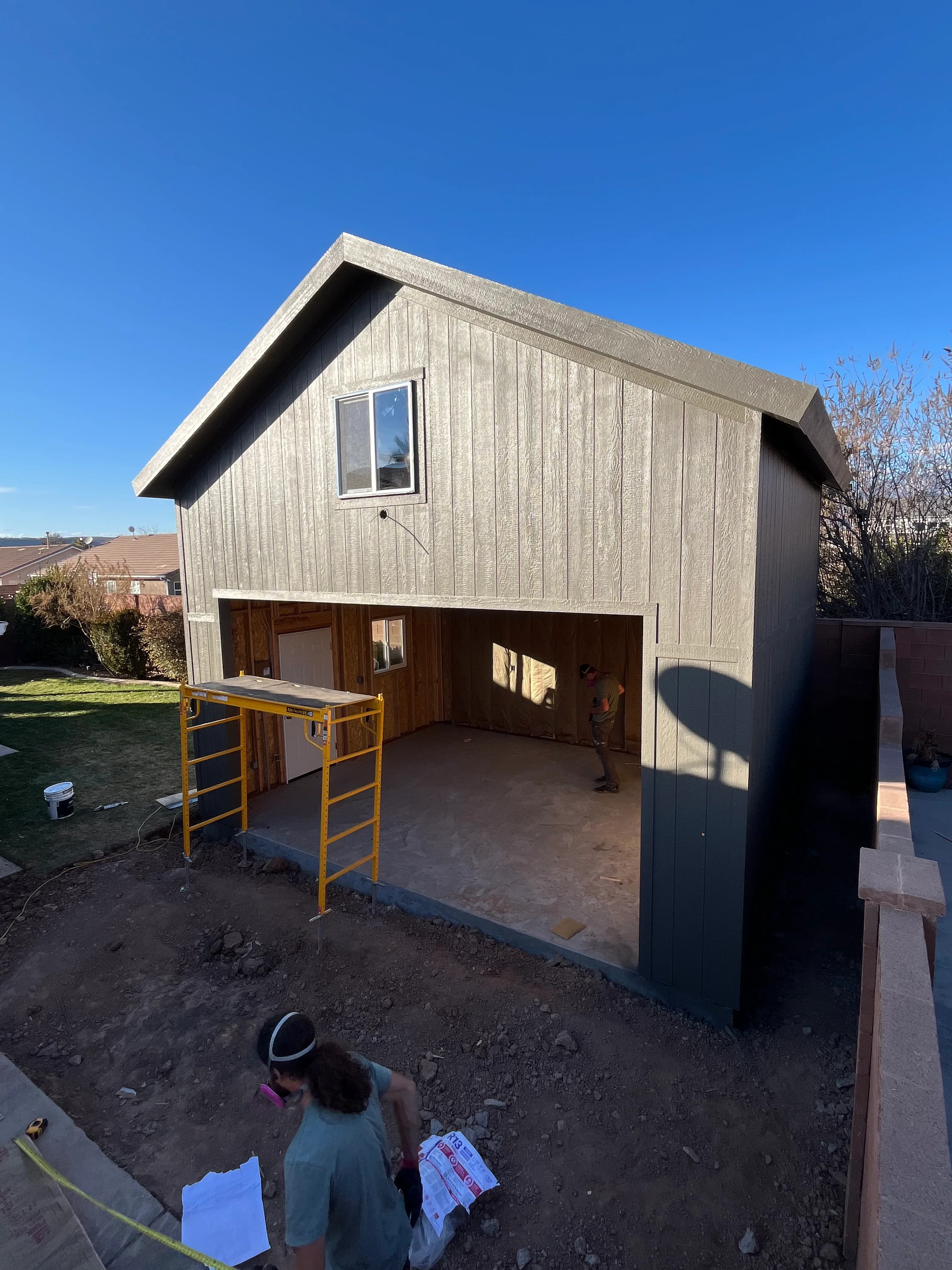 Two-story garage under construction with board-and-batten siding and open bay in Southern Utah